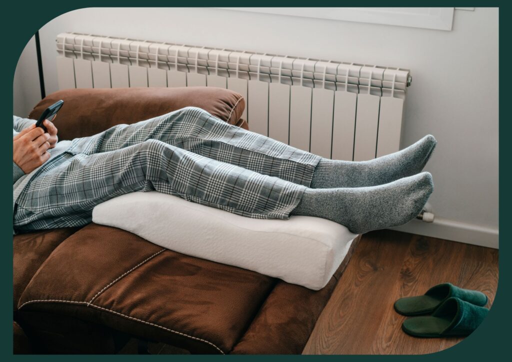 senior leaning his legs on a leg elevation pillow