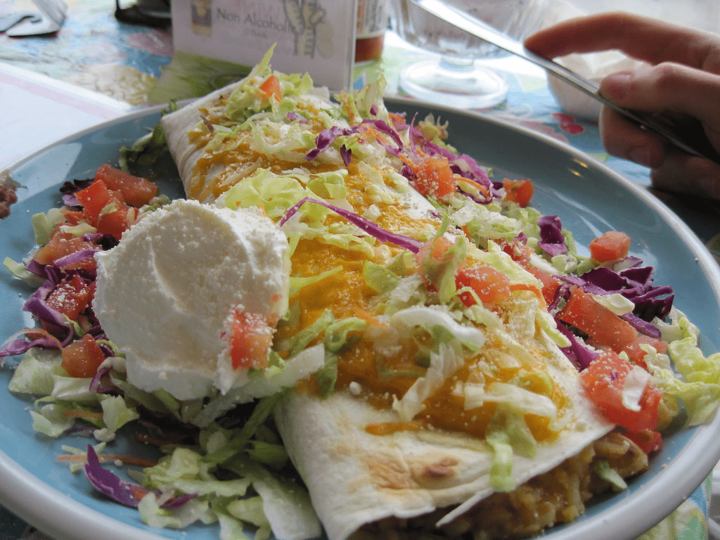 A plate of tacos garnished with fresh salad.