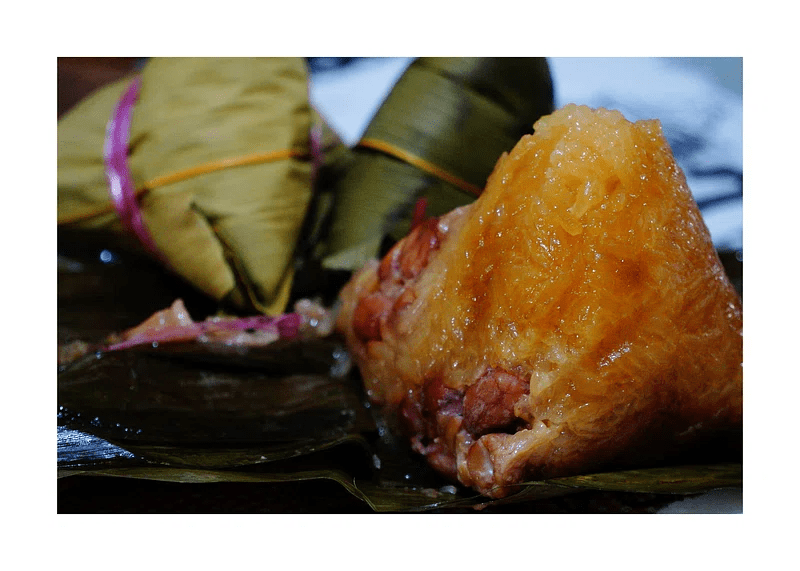 A closeup image of a tamales with meat filling.
