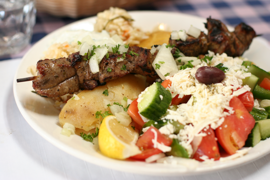 A plate of souvlaki garnished with vegetables.