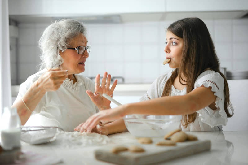 Grandmother and her grand daughter bonding in the kitchen.