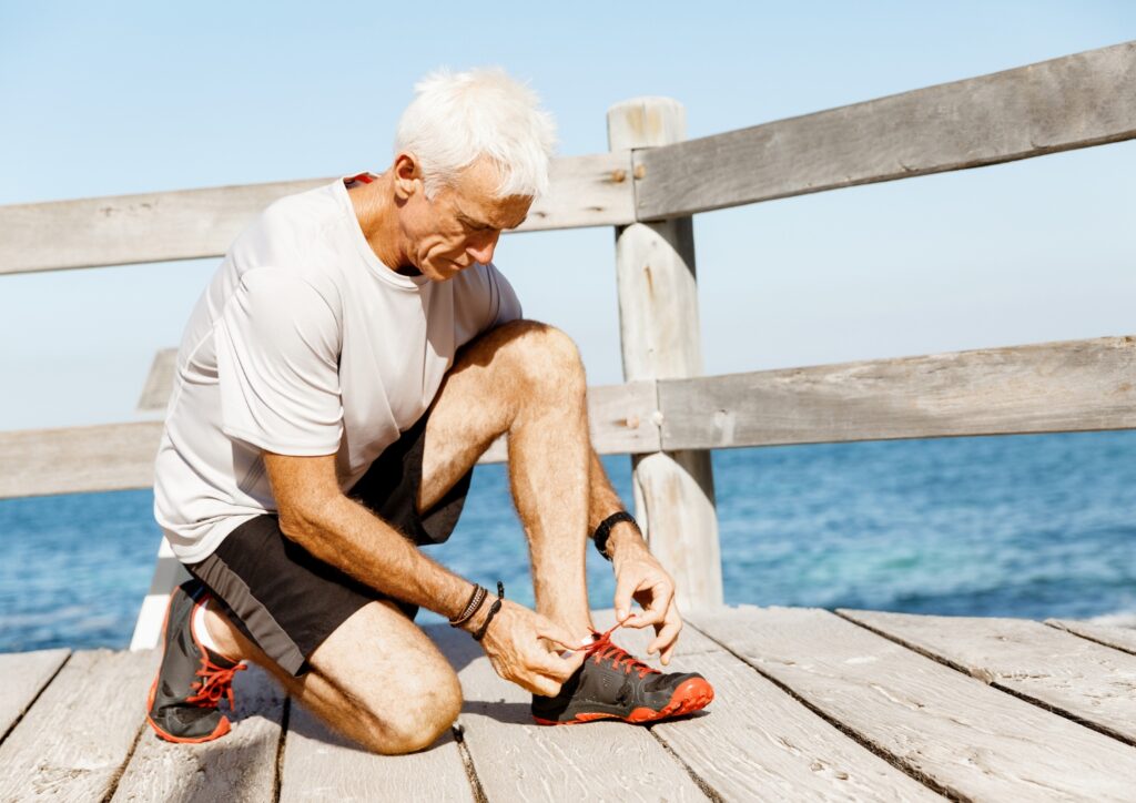 A senior tying his shoe laces