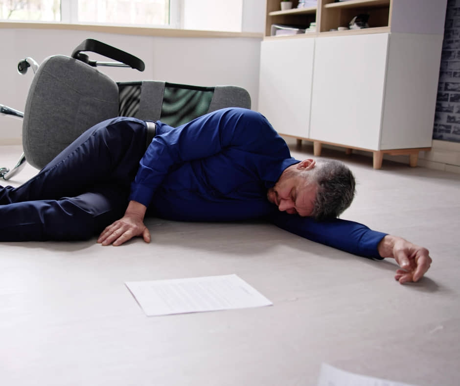 A mature man down on the floor due to fatigue