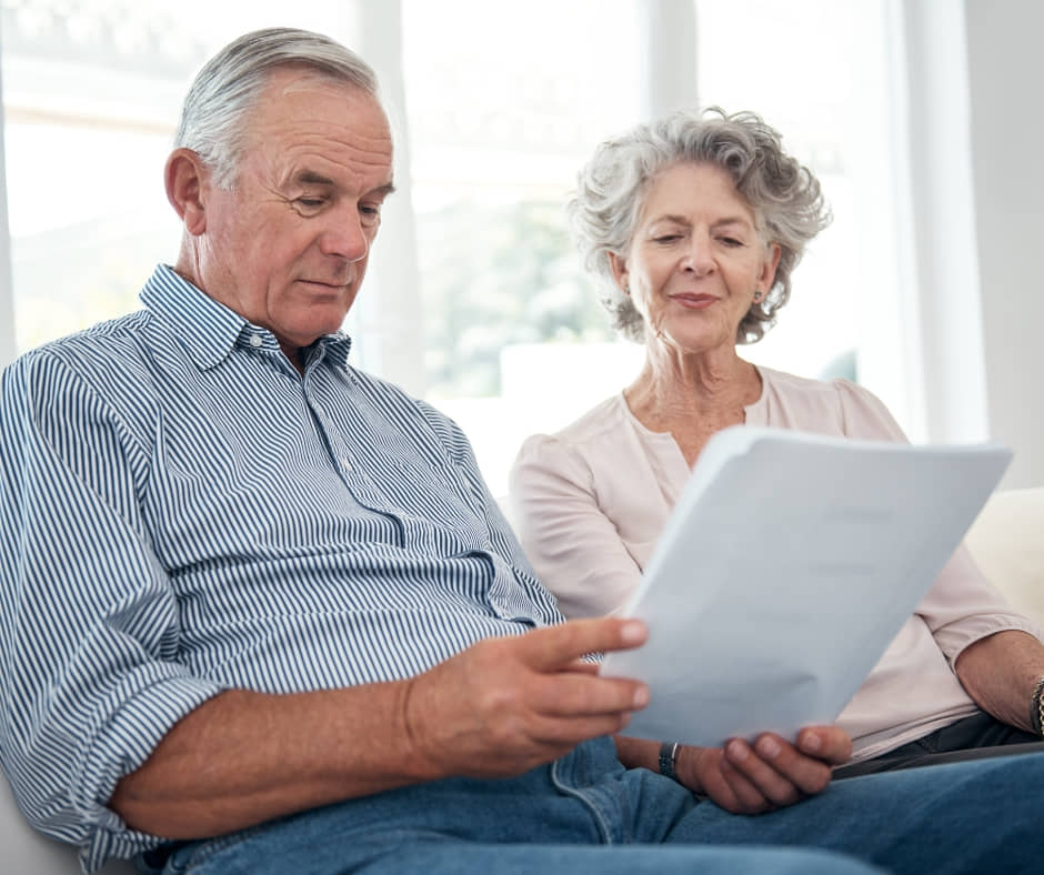 A senior reviewing financial documents at home