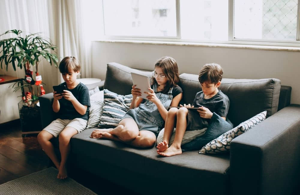Kids standing together while each one scrolls alone
