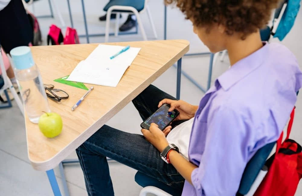 A boy using a phone in school