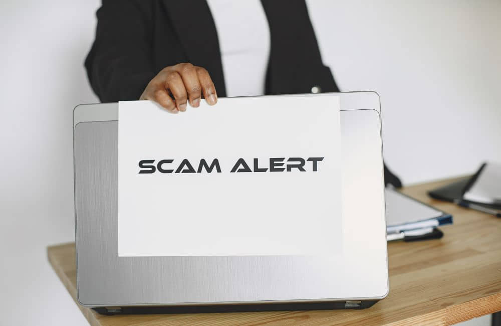 A laptop displaying a scam alert warning